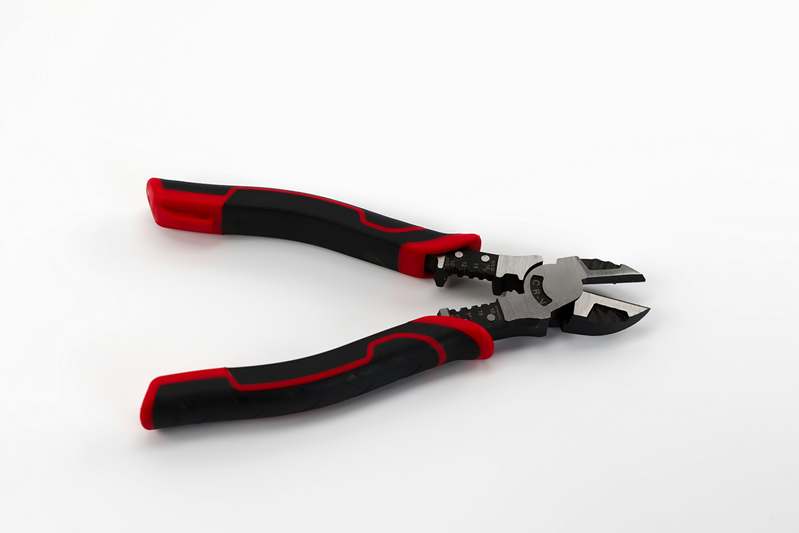 Close-up of professional-grade wire cutters being used on copper electrical wires